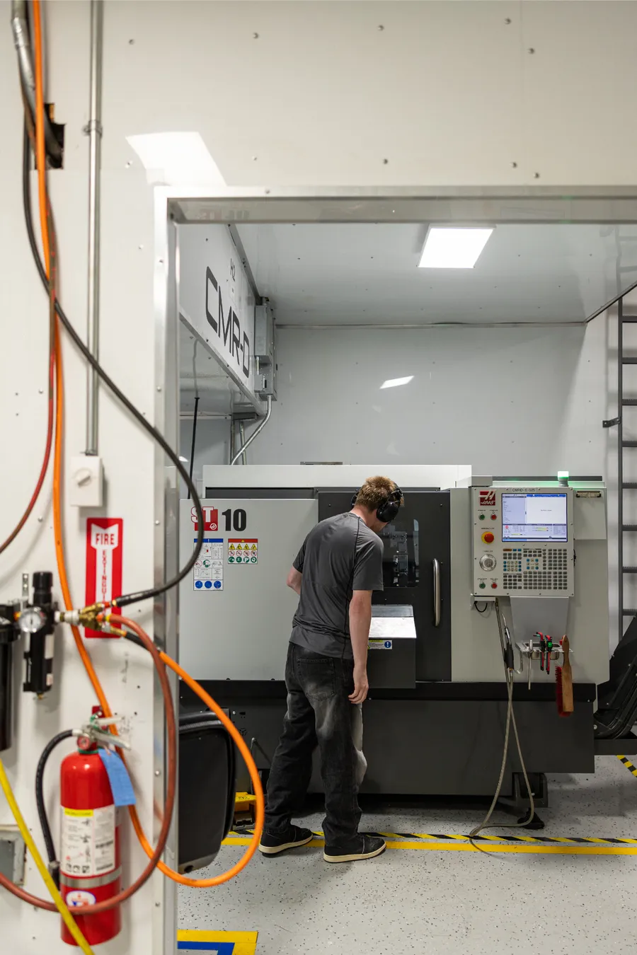 Machinist operating a CNC lathe in the CMR-D machine shop